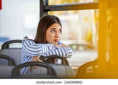 Young Woman In A Public Transport. Woman In Streetcar Alone And Depressed. Young Sad Woman On A Bus. Young Woman Looking Out The Window While Riding The Train