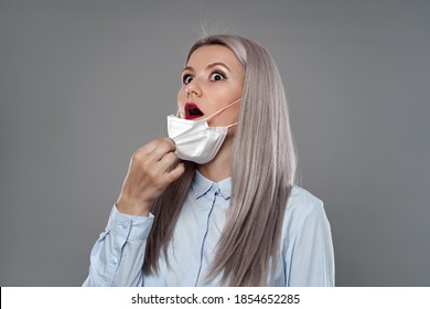 Young Woman Pulling Out Her Face Mask And Gasping For Air