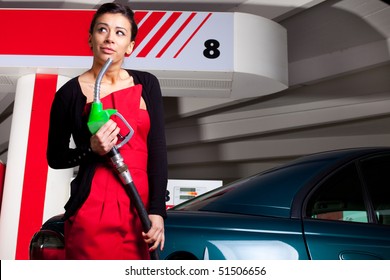 Young Woman Pumping Fuel In Her Car On Gas Station