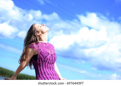 Young Woman In Purple Crochet Dress Facing The Blue Sky.