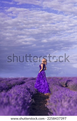 young woman in a purple dress against a beautiful sky in a field of lavender
