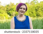 Young woman with purple hair, short haircut in nature.