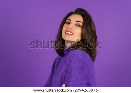 Young woman in a purple soft cozy sweater on the background of cute smiling cheerfully, in high spirits, confident smile, bright makeup with lipstick