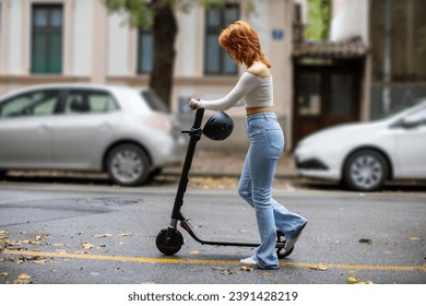 young woman pushing e-scooter in the city - Powered by Shutterstock