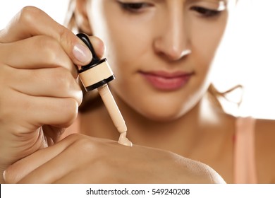 Young Woman Puts A Liquid Foundation On Her Palm