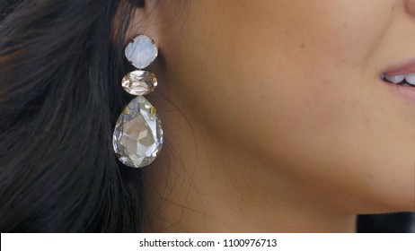 Young Woman Puts On Beautiful Dimond Earring And Smiles