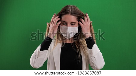 Young woman puts on a medical face mask - studio photography