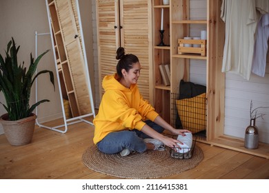 Young Woman Putting Away Towels In The Basket At Home. Selective Focus, Soft Focus, Defocused