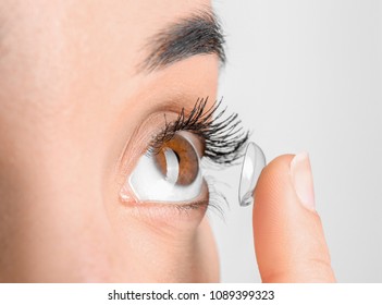 Young woman putting contact lens in her eye, closeup - Shutterstock ID 1089399323