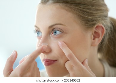 Young Woman Putting Eye Contact Lense On