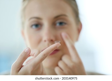 Young Woman Putting Eye Contact Lense On