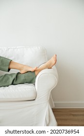 Young woman putting her feet up on sofa