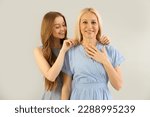 Young woman putting necklace around her mother