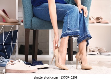 Young Woman Putting On High Heels In Dressing Room