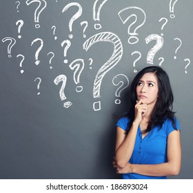 Young Woman With Question Mark On A Gray Background