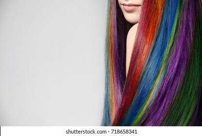 Young Woman With Rainbow Dyed Hair On Light Background