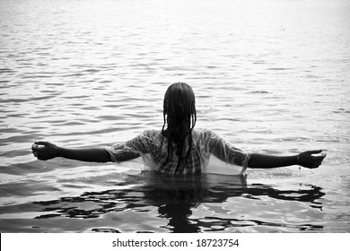 Young woman with raised arms in the water. Black and white.