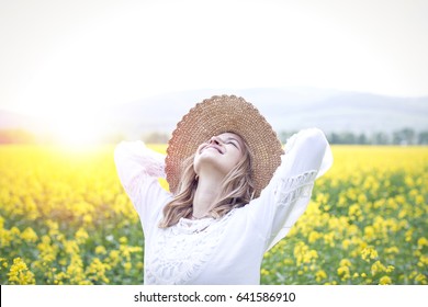 young woman in a rapeseed field - Shutterstock ID 641586910