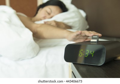 Young Woman Reach Out One's Hand Press The Button To Turn Off The Digital Alarm Clock In Morning.