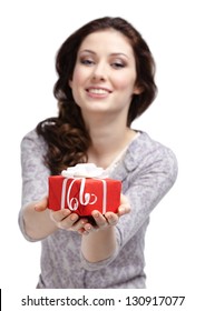 Young woman reaches out a present wrapped in red paper, isolated on white