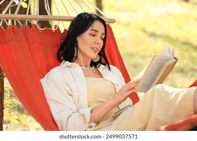 Young woman reading book in hammock outdoors - Powered by Shutterstock