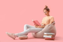 Young Woman Reading Book On Pink Background