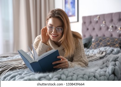 Young Woman Reading Book On Bed At Home