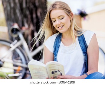 Junge Frau liest im Park ein Buch