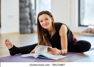 Young Woman Reading A Book While In A Yoga Posture