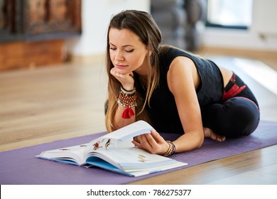 Young Woman Reading A Book While In A Yoga Posture