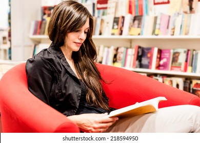 Young Woman Reading Books In A Bookstore