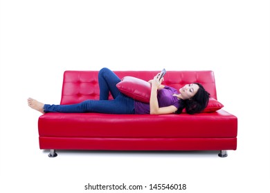 Young Woman Reading E-book On The Couch - Isolated On White