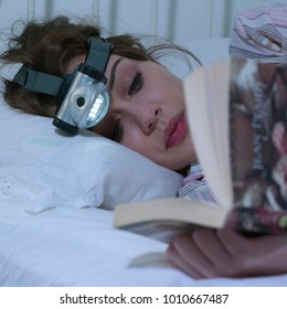 Young Woman Reading With Head Torch