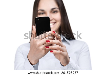 Young woman reading a message and smiling, isolated on white background