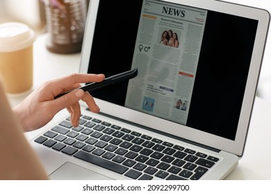 Young woman reading newspaper online at home