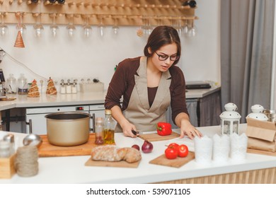 Young Woman Reading A Recipe From The Book