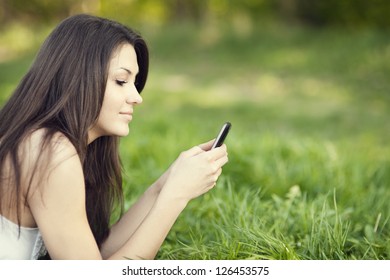 Young Woman Reading Text On Meadow