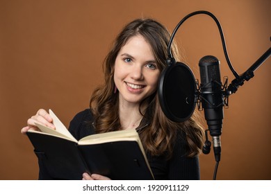 A young woman reads for a podcast as a voice actor 