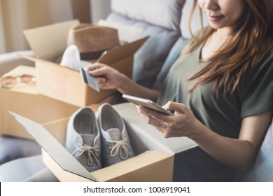 young woman received online shopping parcel opening boxes and buying fashion items by using credit card, Shop online and delivery concept