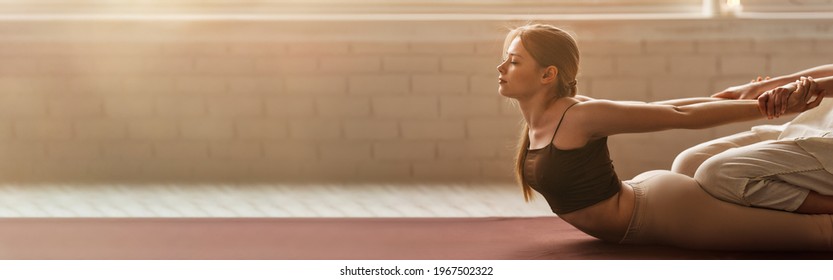 Young woman receives Thai massage at spa salon. Sunny atmosphere and warm colors. Long image crop for text design. - Shutterstock ID 1967502322