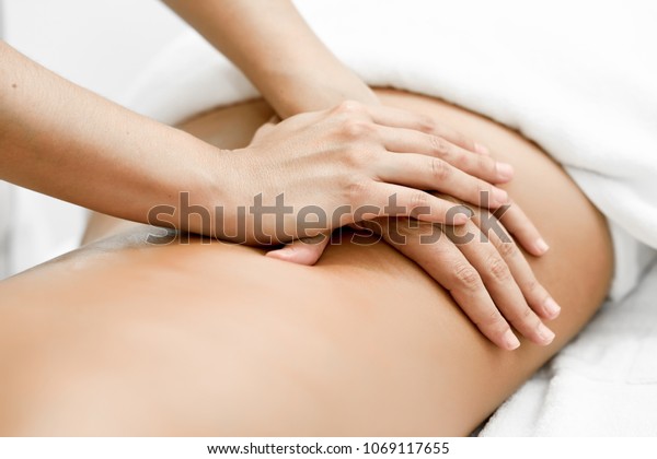 Young\
woman receiving a back massage in a spa center. Female patient is\
receiving treatment by professional\
therapist.