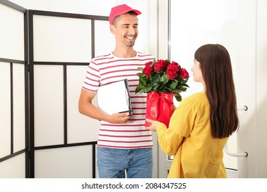 Young Woman Receiving Flowers From Courier At Home