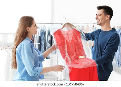 Young woman receiving her dress at dry-cleaner's
