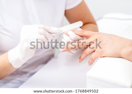 Similar – Woman filing nails in colored background