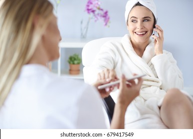 Young Woman Receiving Manicure In Nail Salon