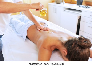 Young Woman Is Receiving Massage With Oil For Her Back In Day Spa