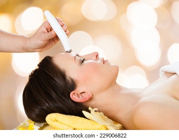 Young Woman Receiving Microdermabrasion Therapy On Forehead At Beauty Spa