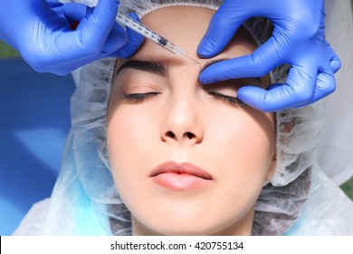 Young woman receiving plastic surgery injection on her face, closeup