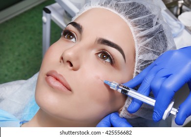Young woman receiving plastic surgery injection on her face, closeup