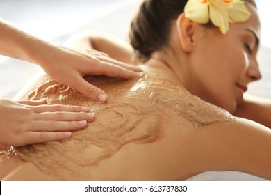 Young Woman Receiving Scrub Massage In Spa Salon